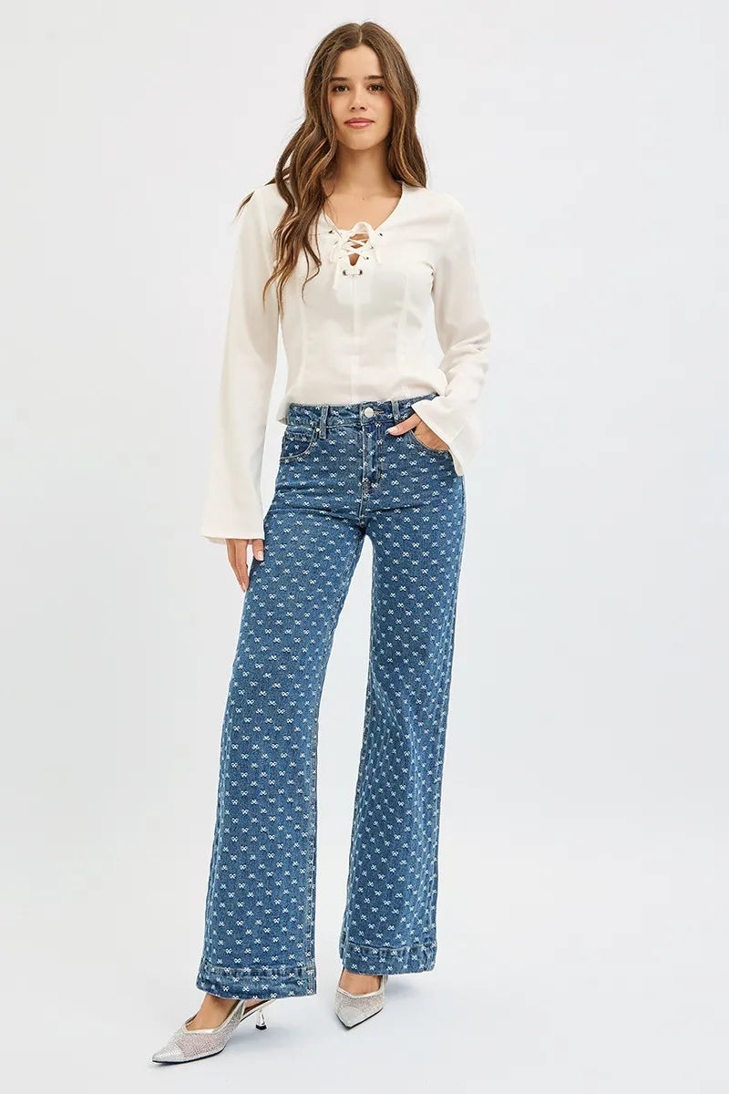 Woman wearing a white blouse and blue patterned pants on a white background