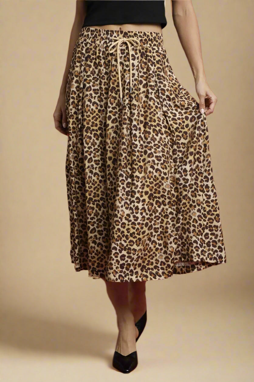 Leopard print skirt worn by a person on a beige background