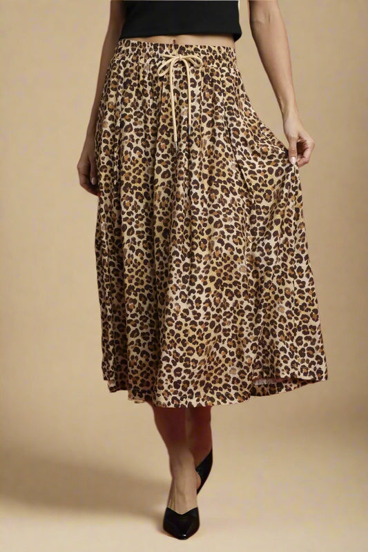 Leopard print skirt worn by a person on a beige background