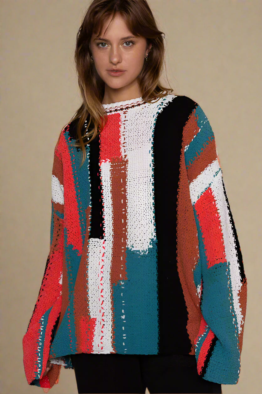 Woman wearing a colorful patterned sweater against a light background