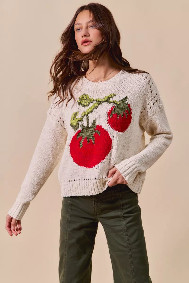 Woman wearing a sweater with tomato design on a beige background