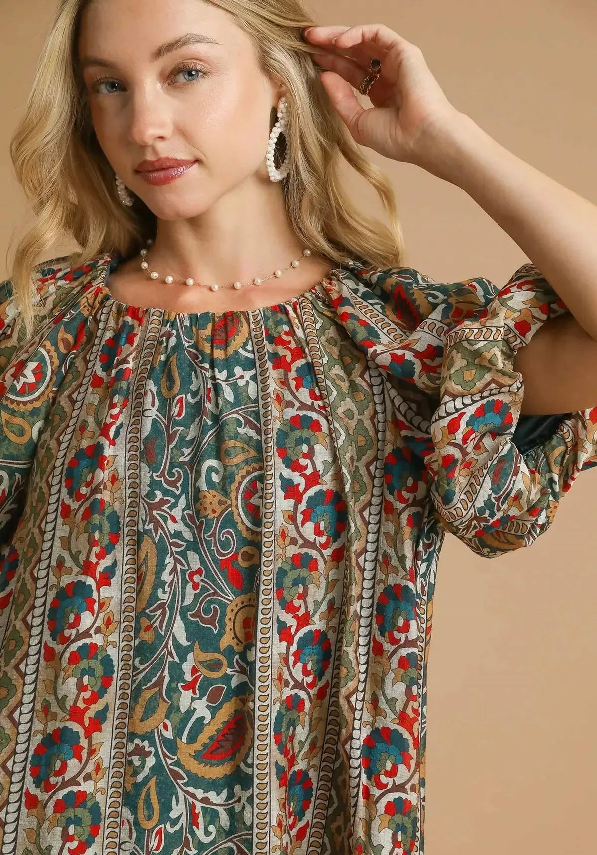 Woman wearing a patterned blouse with a beige background