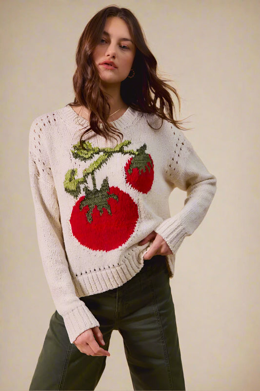 Woman wearing a sweater with tomato design on a beige background