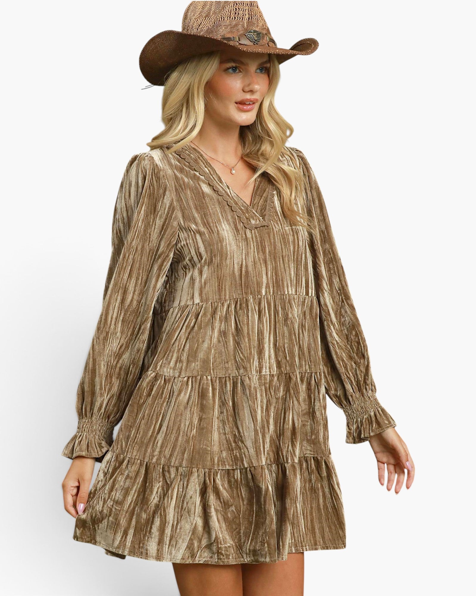 A woman wearing a bronze-brown tiered long-sleeve dress with a crinkled metallic texture, paired with a matching brown cowboy hat, against a plain white background.