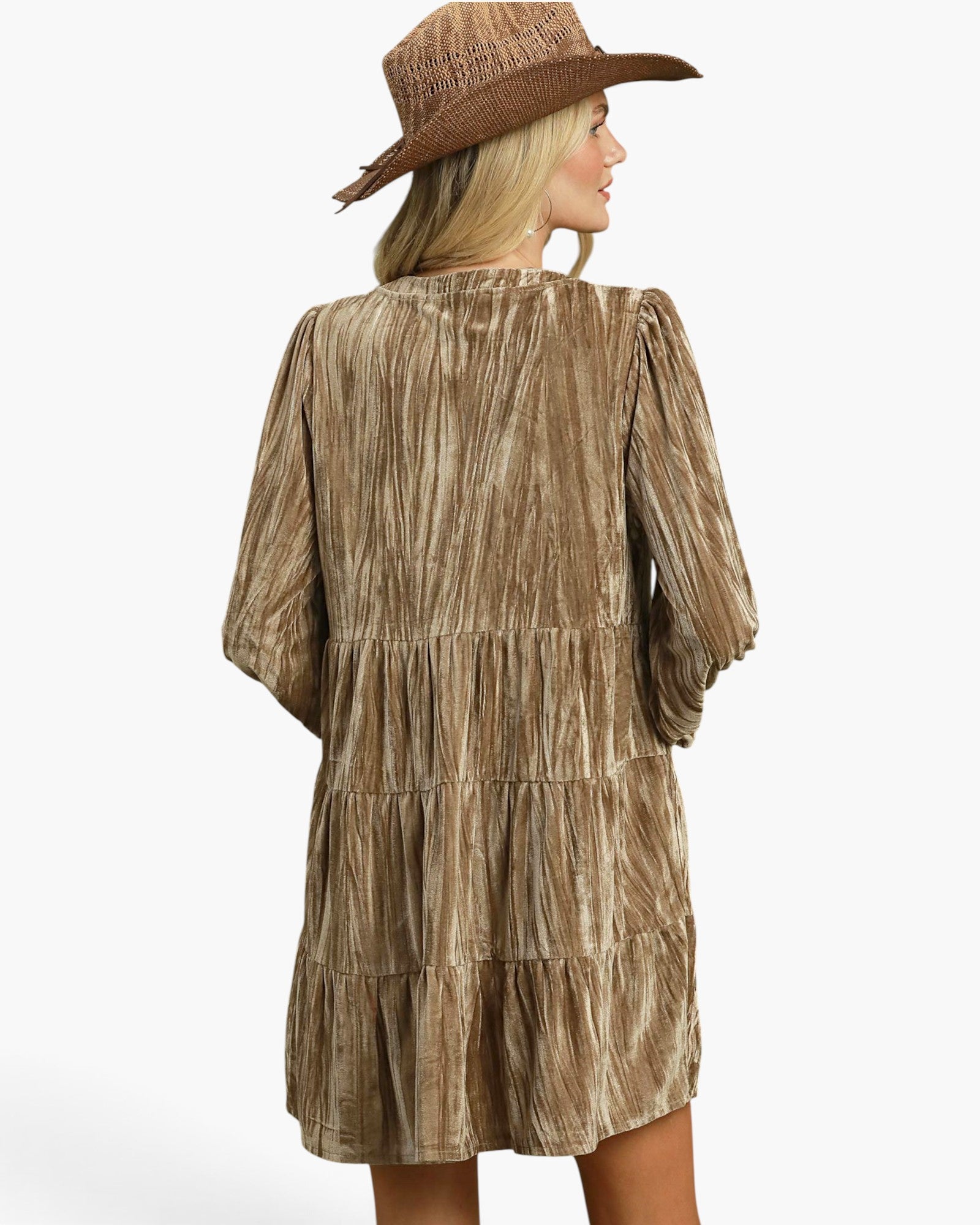 A woman shown from the back wearing a brown tiered dress with a textured, crinkled metallic finish and a matching brown woven hat, set against a plain white studio background.