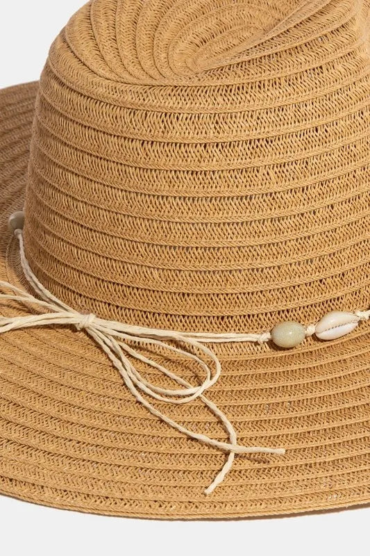 Beige straw hat with a decorative string and beads on a white background