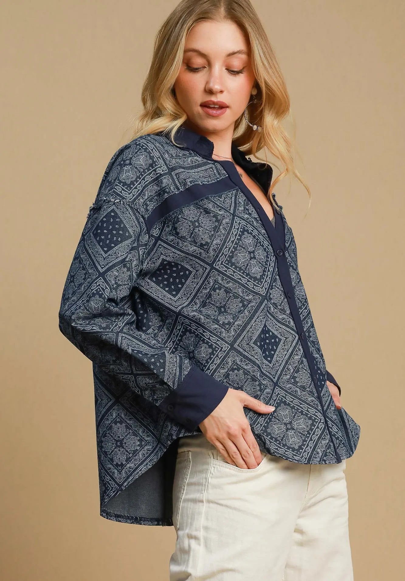 Woman wearing a dark denim patterned jacket against a beige background