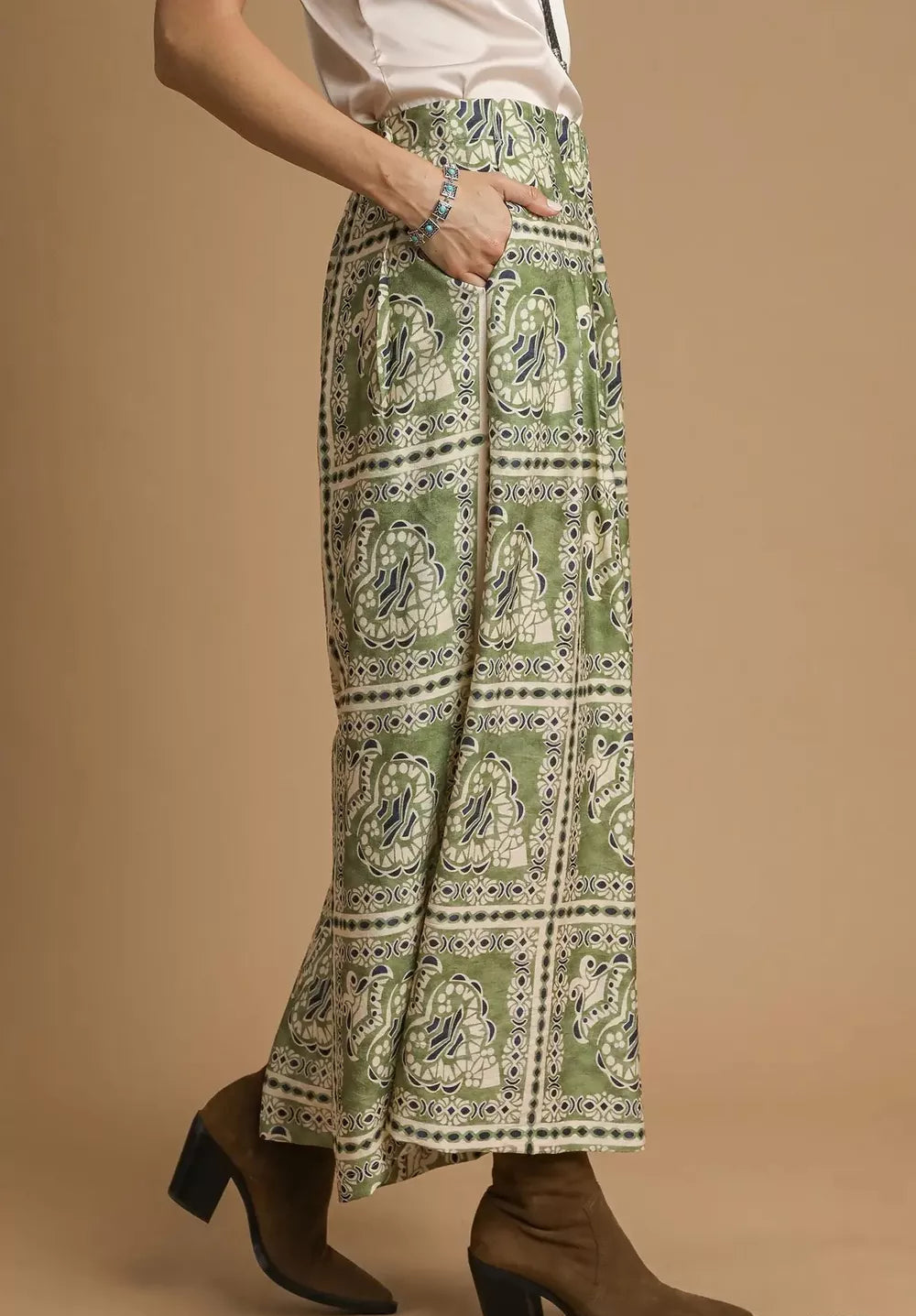 Green patterned skirt worn by a person on a beige background
