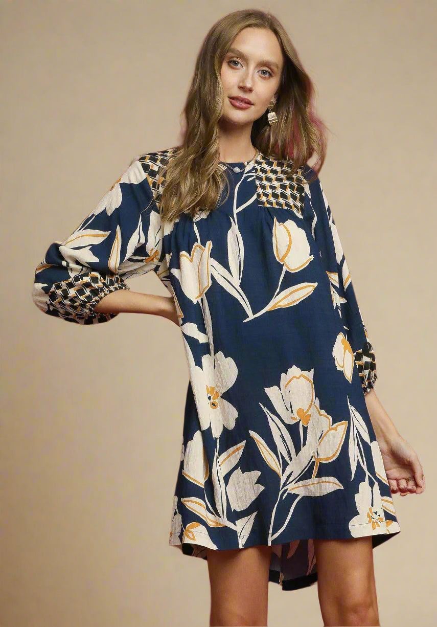 Woman wearing a floral dress with long sleeves on a red background
