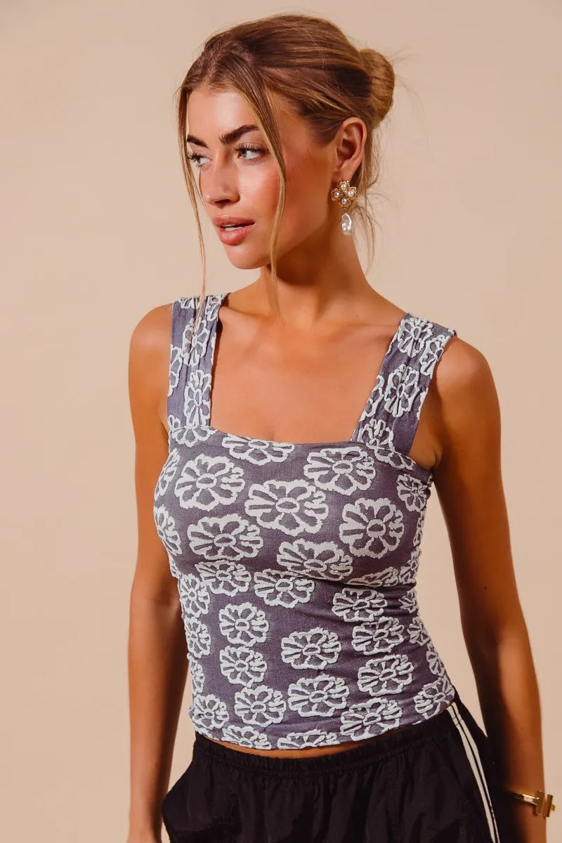 Woman wearing a patterned tank top against a beige background