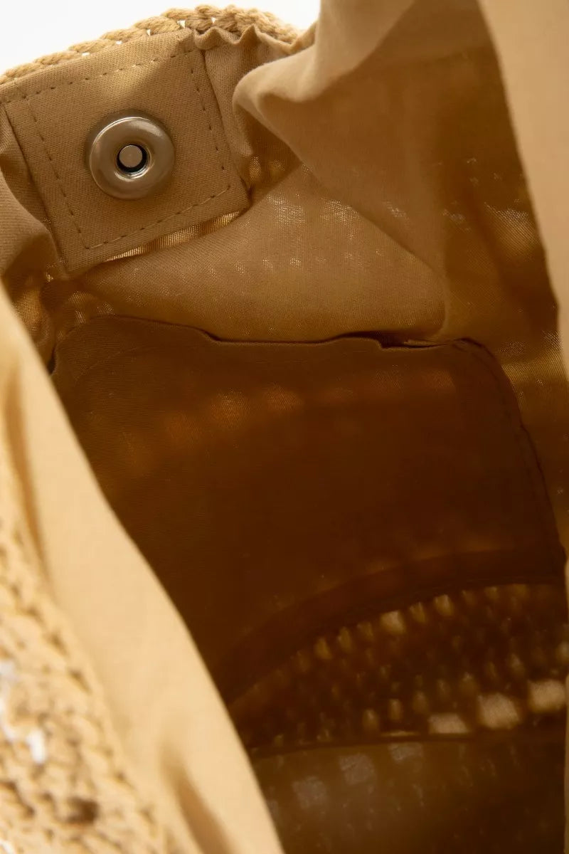 Close-up of a beige fabric with a button and textured pattern