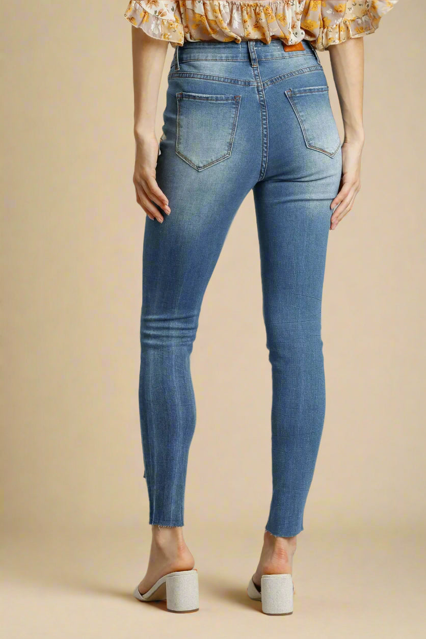 Person wearing blue jeans on a beige background