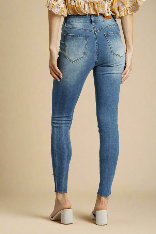 Person wearing blue jeans on a beige background