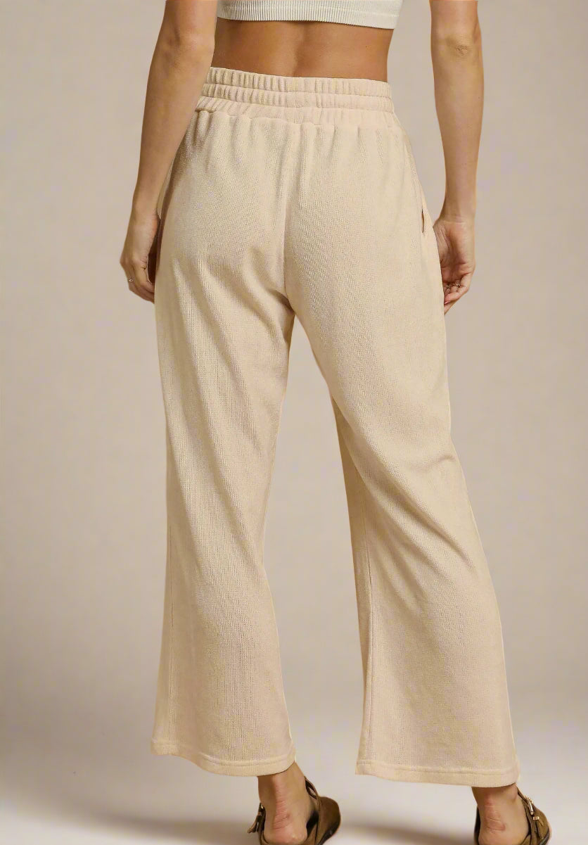 Beige pants worn by a person on a beige background