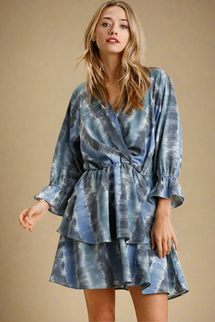 Woman wearing a blue tie-dye dress on a beige background