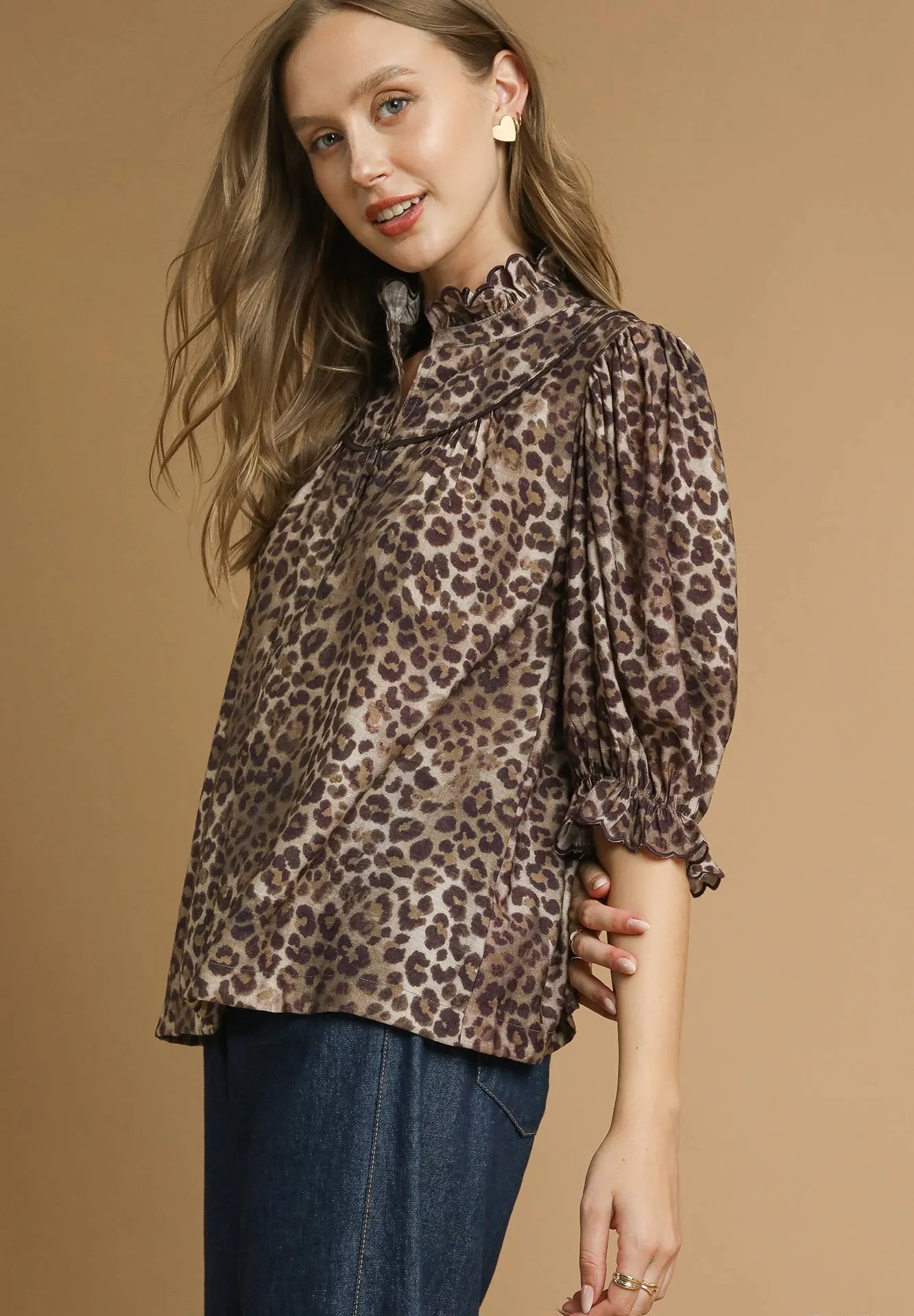 Woman wearing a leopard print blouse against a beige background
