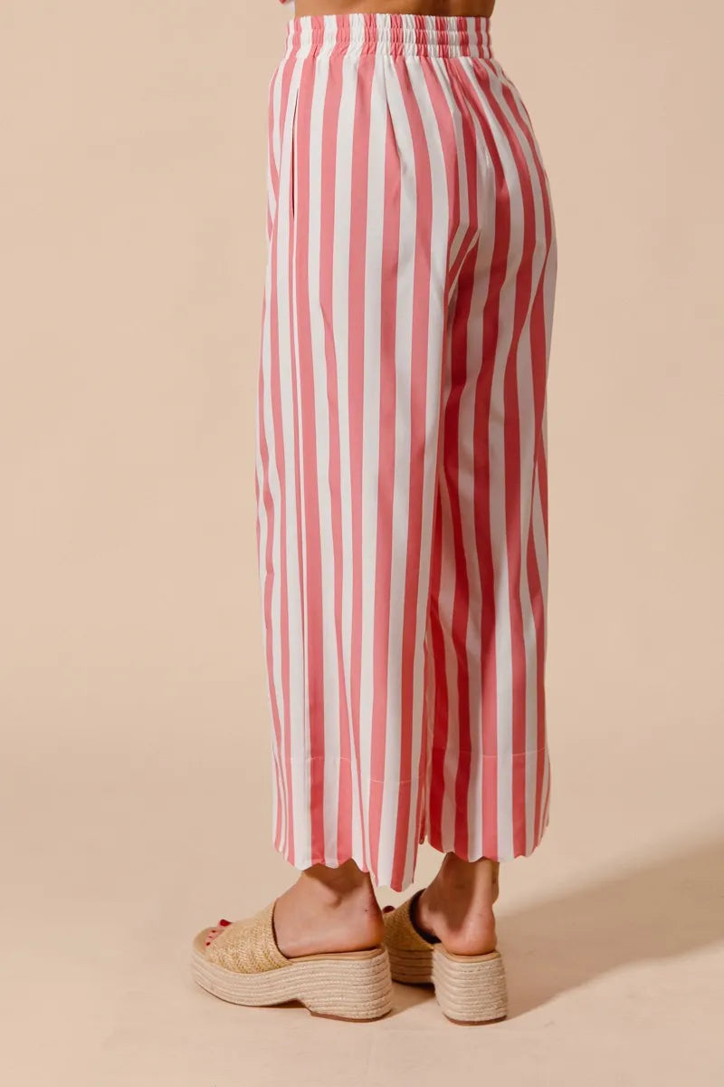 Red and white striped pants worn by a person on a beige background