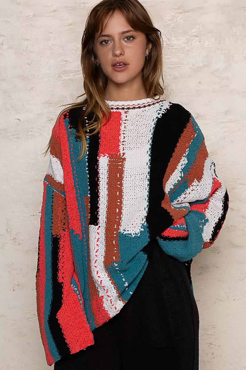 Woman wearing a colorful, patterned sweater against a neutral background
