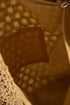 Close-up of a textured brown fabric with a patterned background