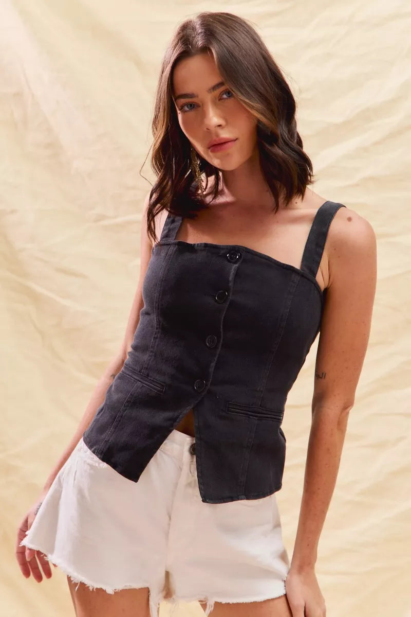 Woman wearing a black top and white shorts against a beige background