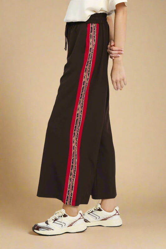Brown wide-leg pants with a red and gold stripe on a white background