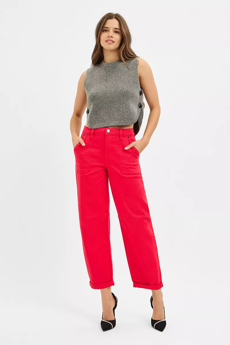 Woman wearing a gray sleeveless top and red pants on a white background