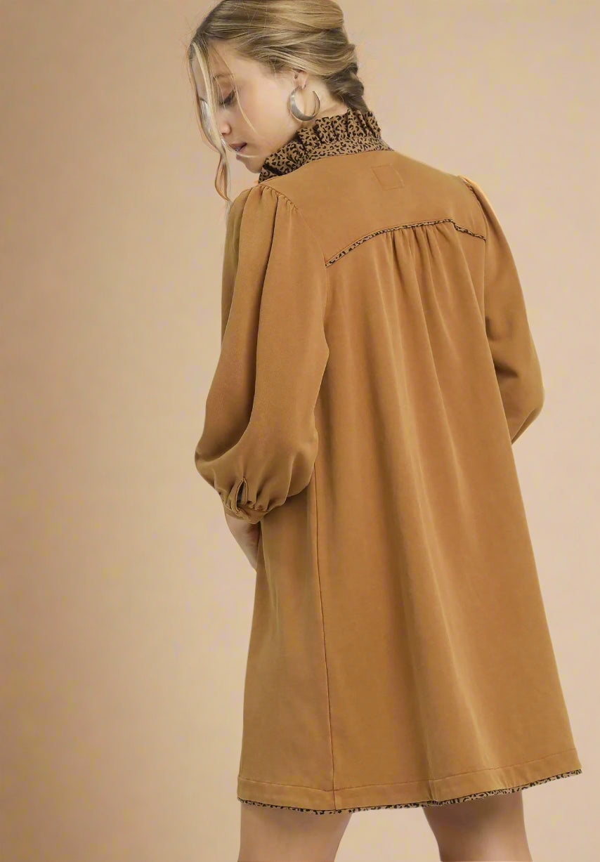 Brown dress worn by a person on a beige background