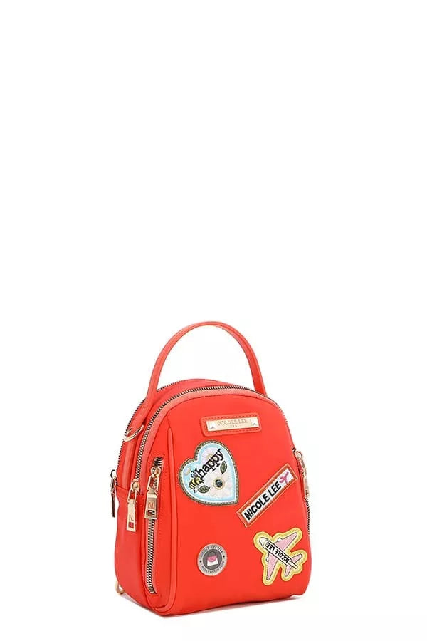 Red backpack with decorative patches on a white background