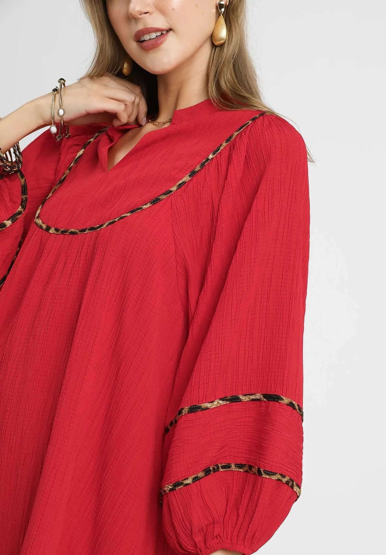 Red dress with black trim worn by a model on a white background