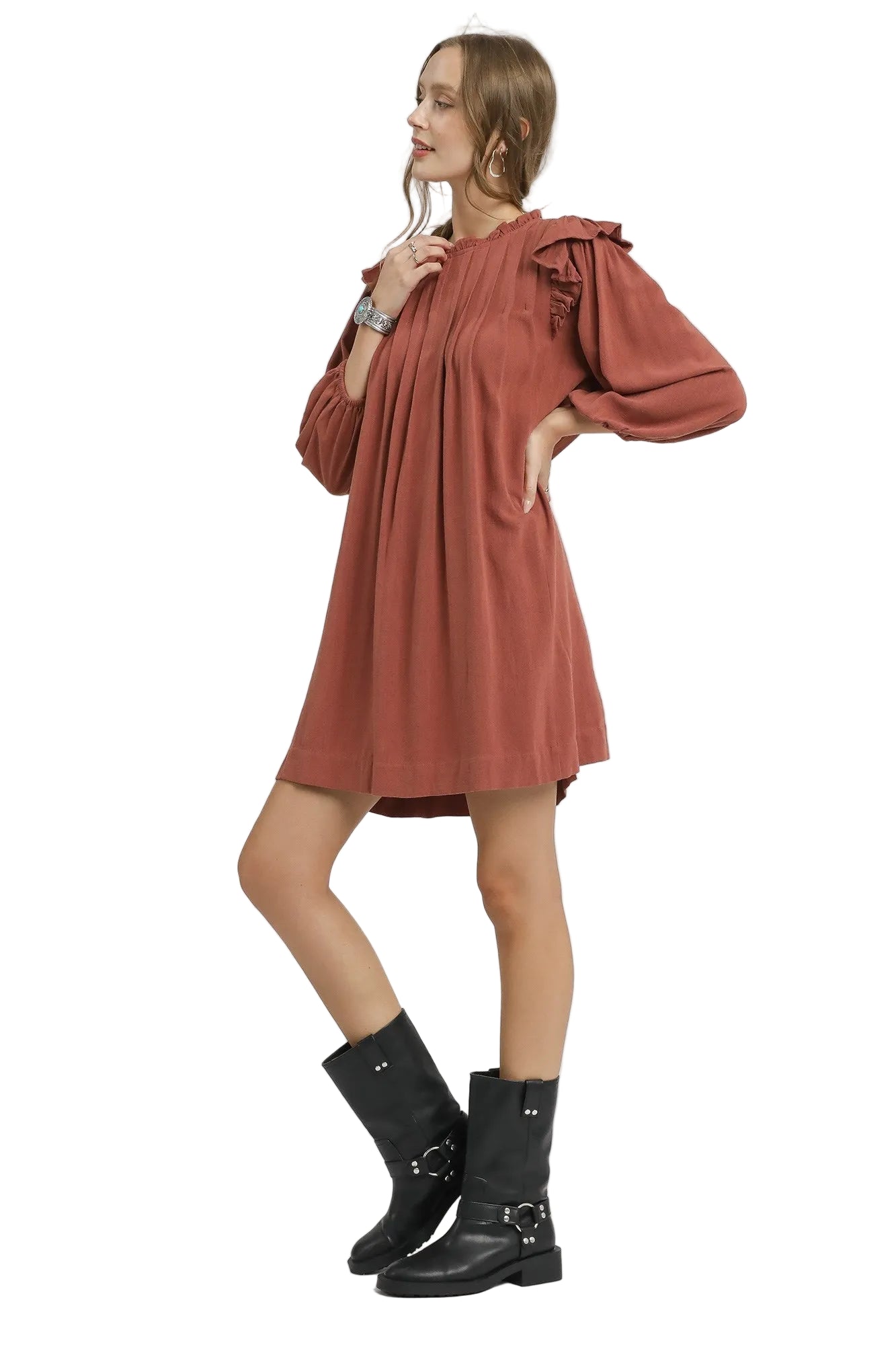 Woman wearing a rust-colored dress with puffed sleeves on a white background