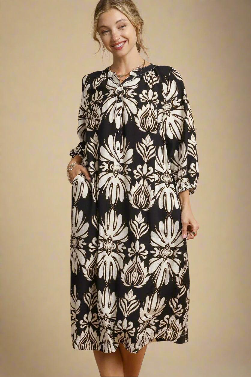 Woman wearing a black and white floral dress against a beige background
