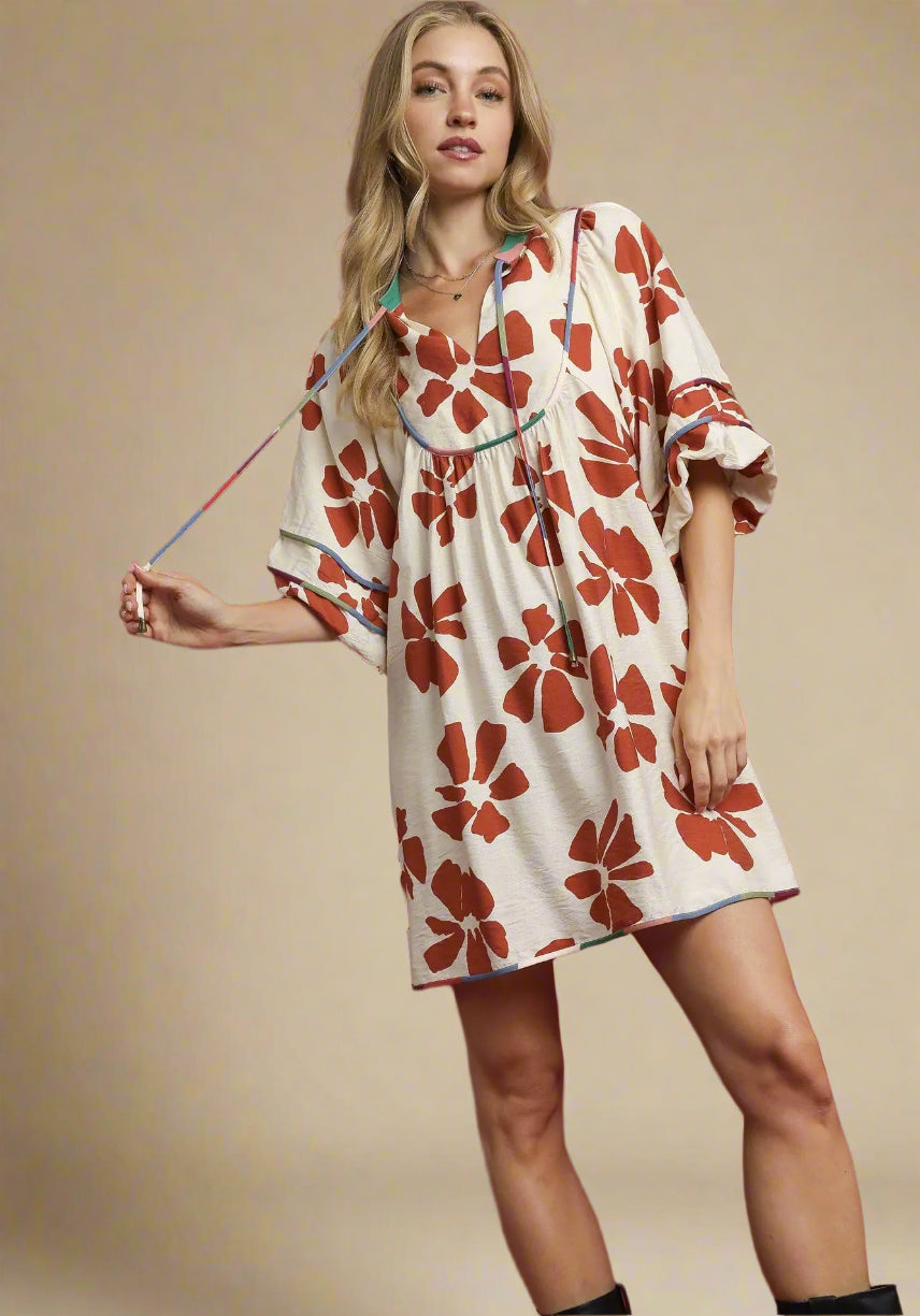Woman wearing a floral dress against a beige background