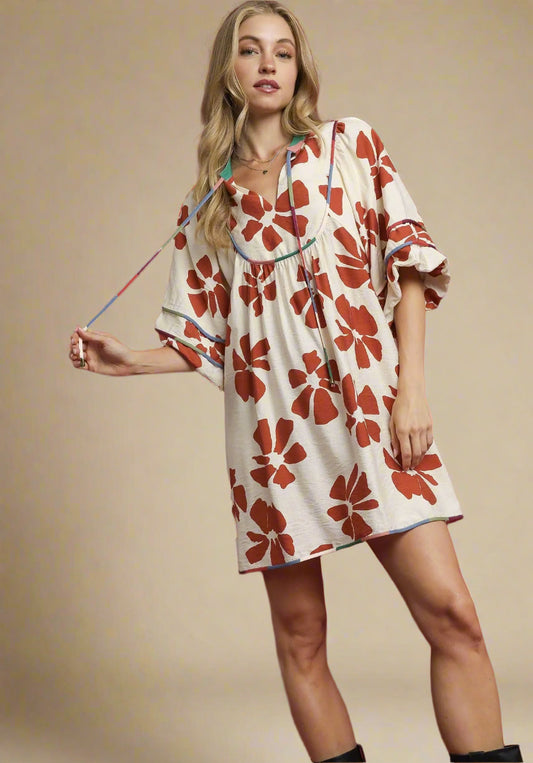 Woman wearing a floral dress against a beige background