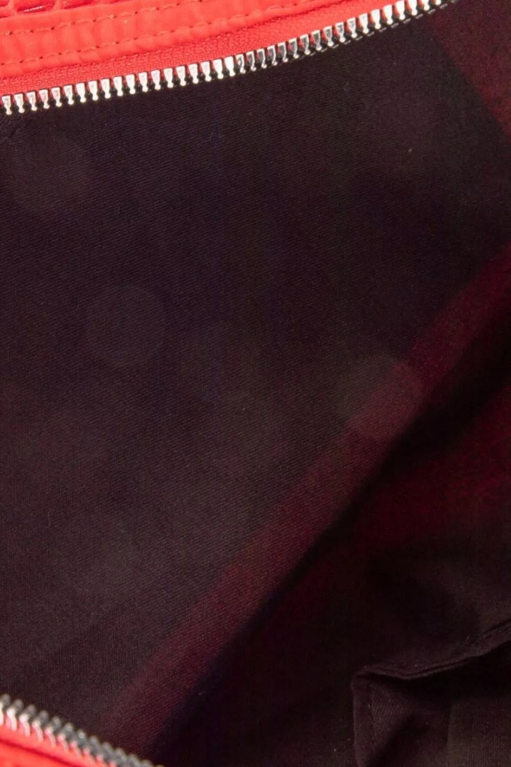 Close-up of a red zipper on a dark fabric background