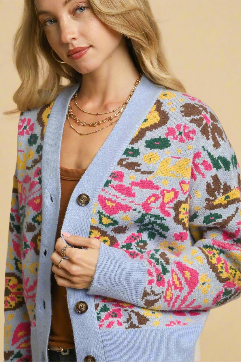 Woman wearing a colorful patterned cardigan with a beige background
