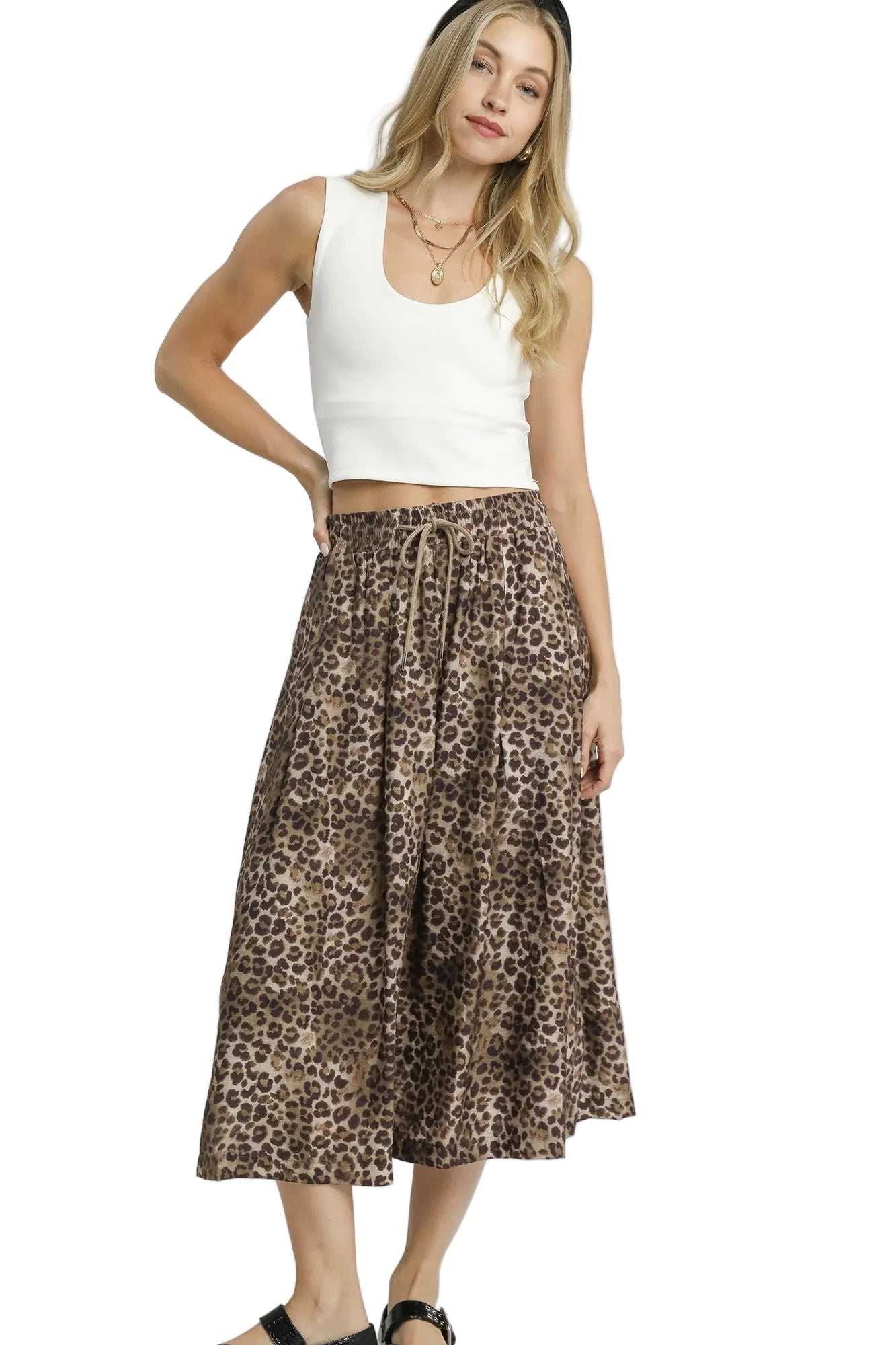 Woman wearing a white tank top and leopard print skirt on a white background