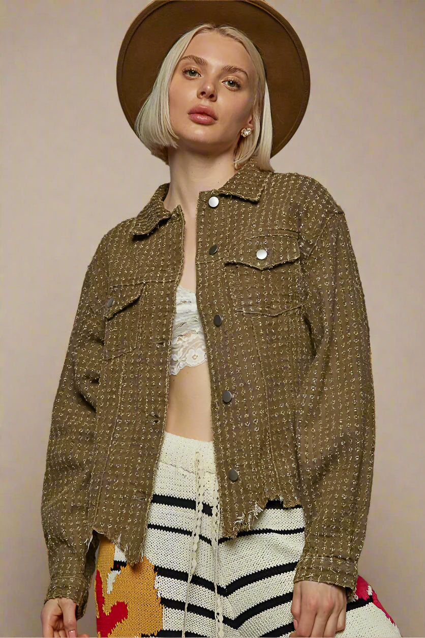 Woman wearing a brown textured jacket and hat against a beige background