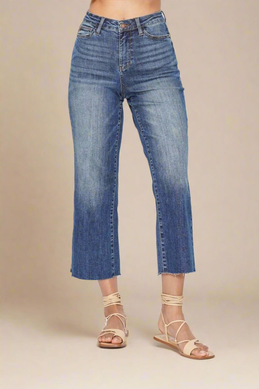 Blue jeans worn by a person on a beige background