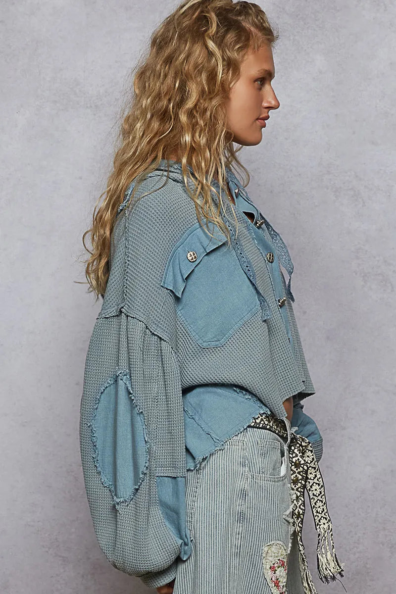Woman wearing a layered denim outfit against a gray background