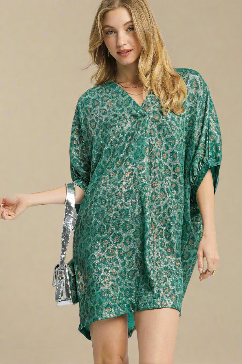 Woman wearing a teal leopard print dress on a white background