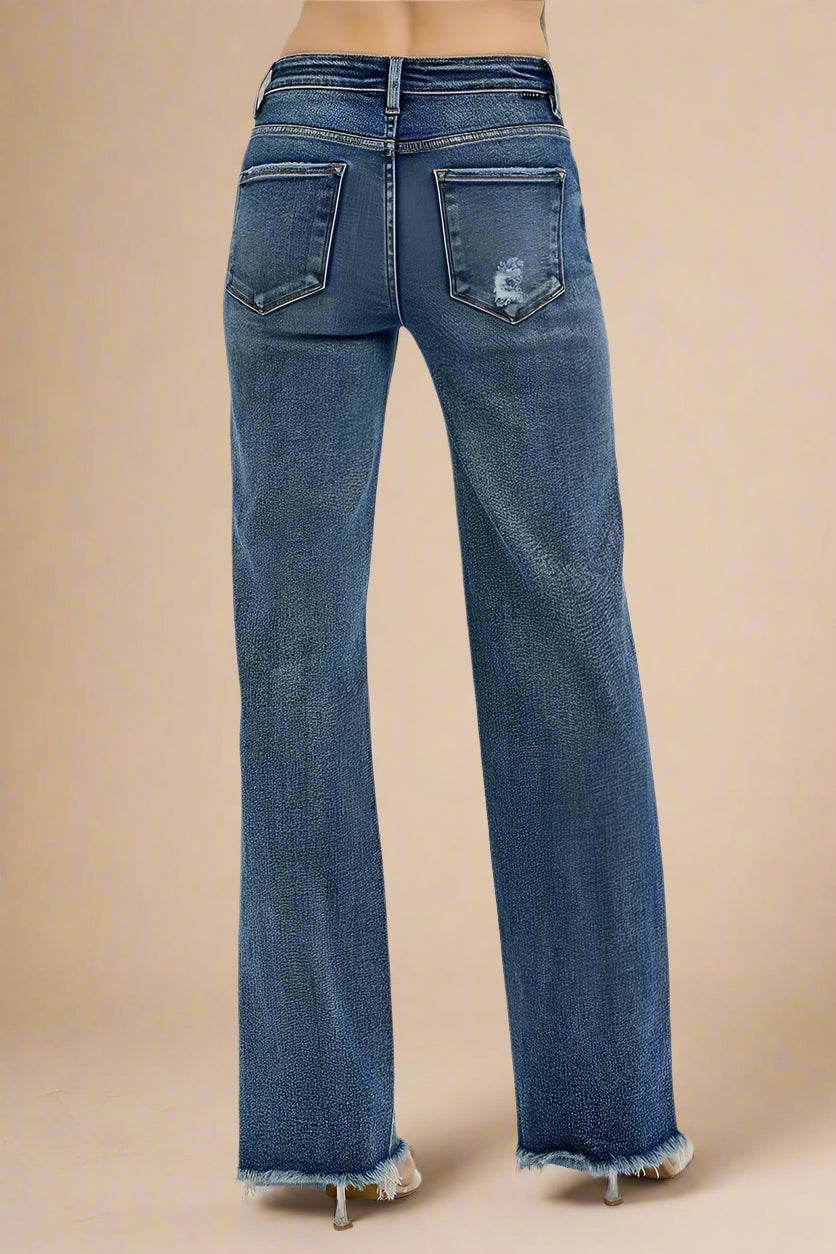 Blue jeans with a distressed back pocket design on a white background