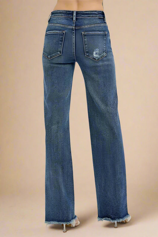 Blue jeans with a distressed back pocket design on a white background