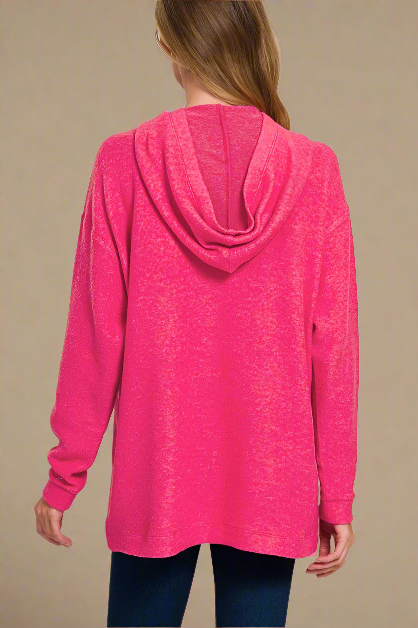 Pink hoodie worn by a person on a beige background
