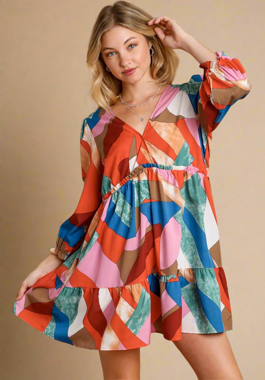 Woman wearing a colorful dress with a wine mix pattern on a beige background
