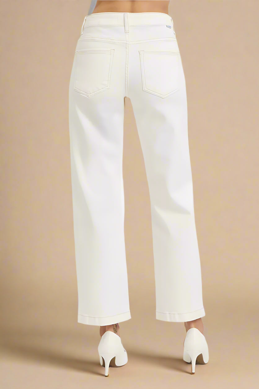 White pants worn by a person on a beige background