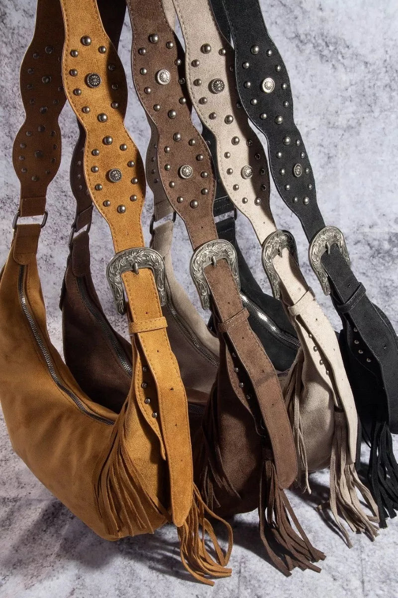 Collection of leather bags with studded details and fringes on a textured surface