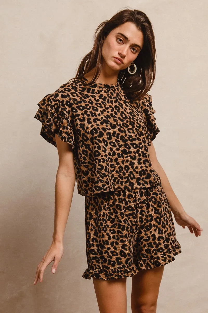 Woman wearing a leopard print outfit against a beige background