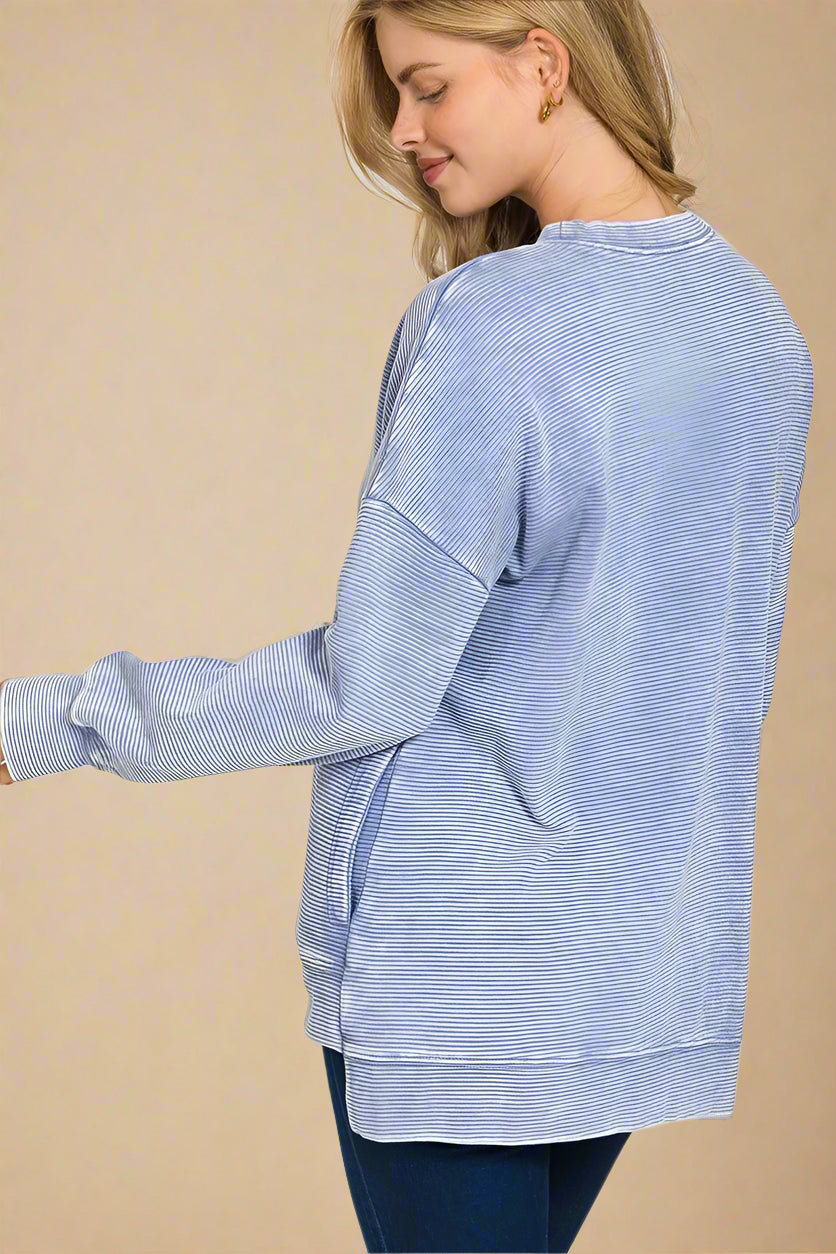 Woman wearing a blue striped shirt with a white background