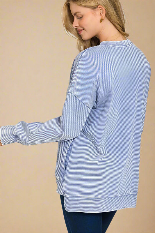 Woman wearing a blue striped shirt with a white background