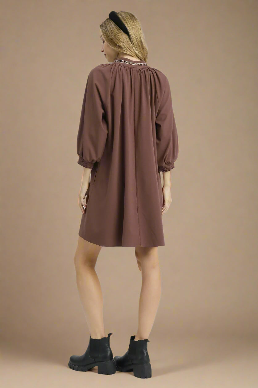 Woman wearing a brown dress on a white background